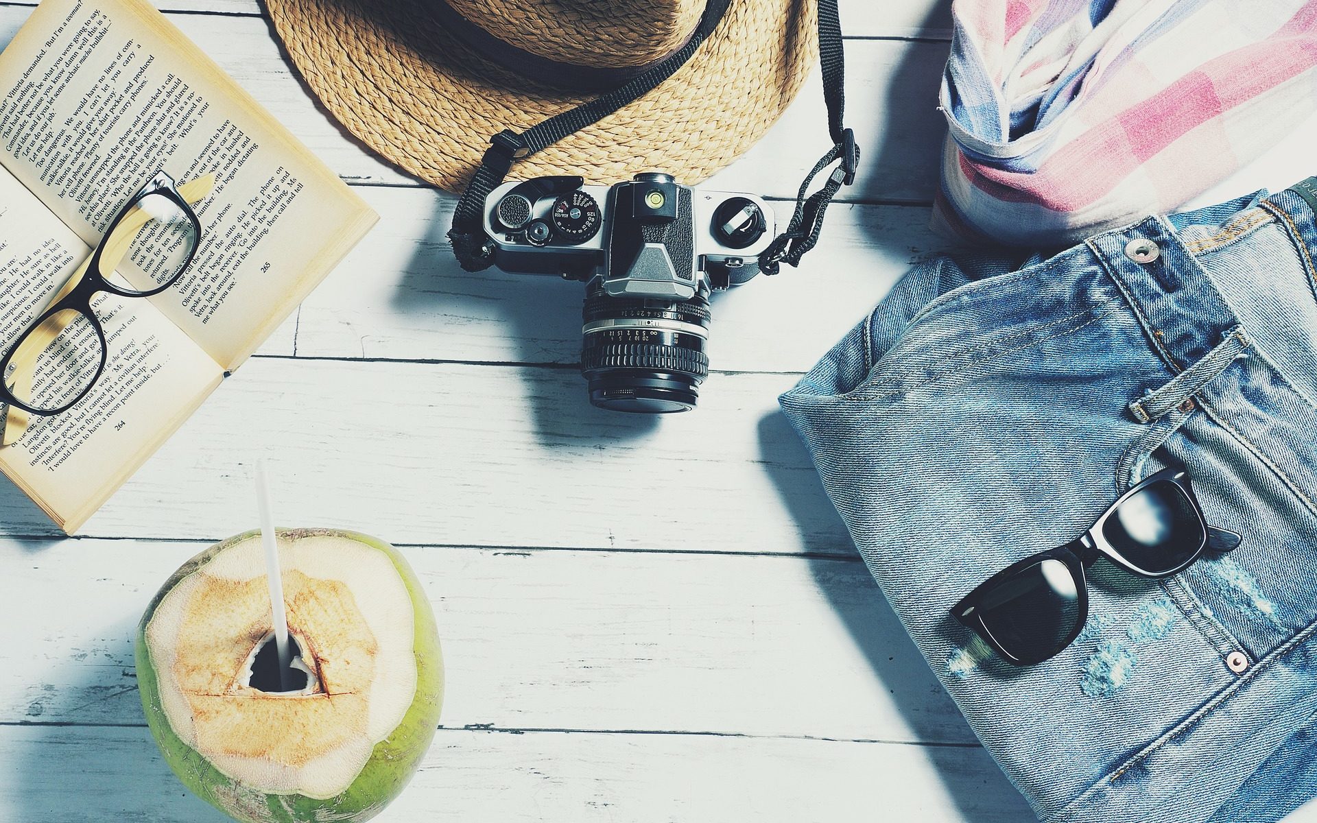melting pot d'objets de vacances : lunettes, appareil photo, chapeau...